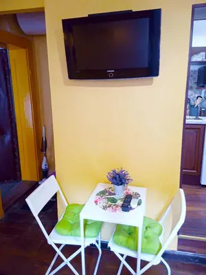 a table with two chairs and a tv on a wall at Jazzy Art Home - Top Center - plus Free Vouchers in Sofia