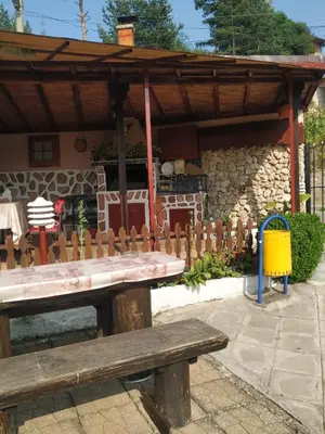 a wooden picnic table in front of a building at Villa Silvinka in Dospat
