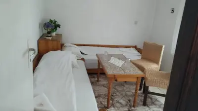a bedroom with a bed and a table and chairs at Villa Silvinka in Dospat