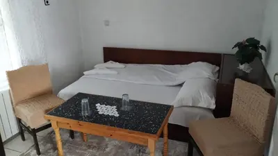 a bedroom with a bed with a table and two chairs at Villa Silvinka in Dospat