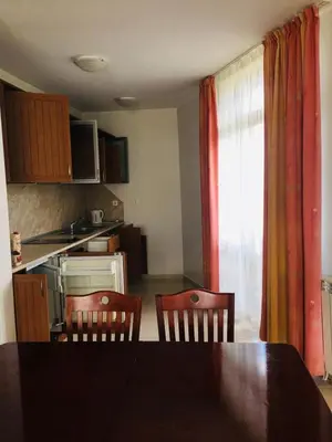 a kitchen with a table and two chairs and a dining room at Beautiful two bedroom 4th floor apartment in Elegant Luxe Hotel with pool, sauna, gym and steam room in Bansko