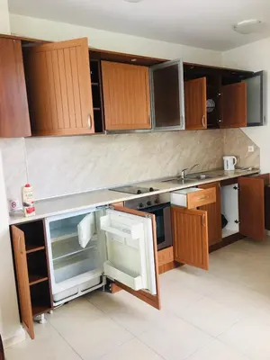 a kitchen with wooden cabinets and an open refrigerator at Beautiful two bedroom 4th floor apartment in Elegant Luxe Hotel with pool, sauna, gym and steam room in Bansko