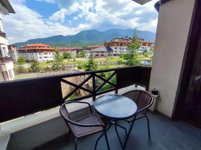 a balcony with two chairs and a table with a view at Aspen Apartment A208 3OOm from Gondola in Bansko
