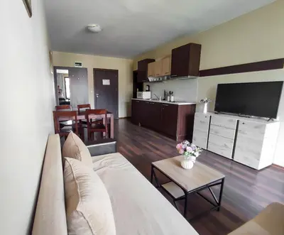a living room with a white couch and a kitchen at Aspen Apartment A208 3OOm from Gondola in Bansko