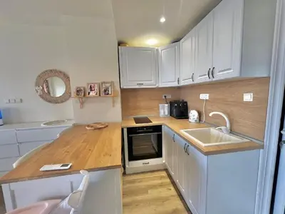 a small kitchen with white cabinets and a sink at Слънчево Студио Алпин Банско! in Bansko
