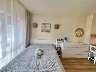 a teddy bear sitting on a bed in a bedroom at Слънчево Студио Алпин Банско! in Bansko