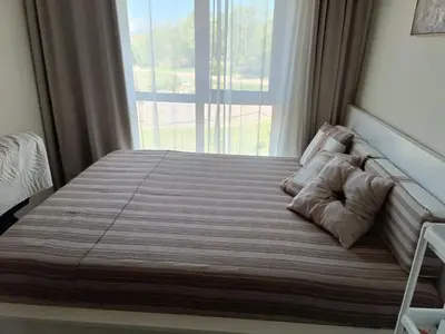 a bed in a bedroom with a large window at Слънчево Студио Алпин Банско! in Bansko
