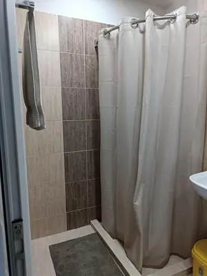 a shower with a shower curtain in a bathroom at Слънчево Студио Алпин Банско! in Bansko