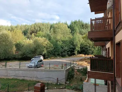 a car parked in a parking lot next to a building at Слънчево Студио Алпин Банско! in Bansko