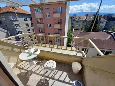 a balcony with a table and chairs on a building at the green apart in Sofia