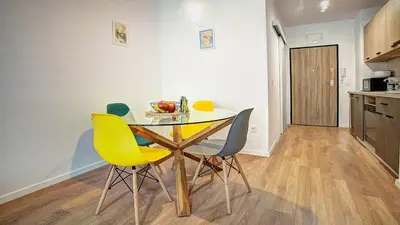 a dining room with a table and yellow chairs at College Flat - Wi-Fi with 600 Mbit speed in Sofia