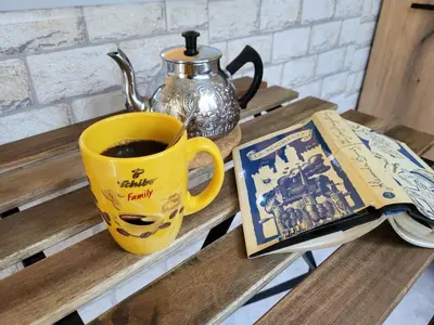 a cup of coffee and a book on a table at Apartament KETI улица Христо Максимов 56 вхВ in Sofia