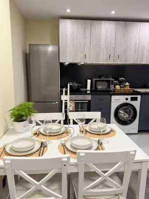 a kitchen with a white table with plates and wine glasses at Top City Centre Apartment 122 in Sofia
