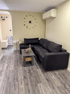 a living room with a black couch and a clock on the wall at Top City Centre Apartment 122 in Sofia