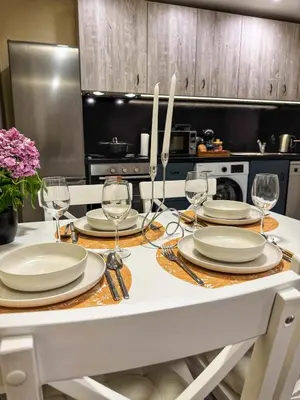 a kitchen with a table with plates and wine glasses at Top City Centre Apartment 122 in Sofia