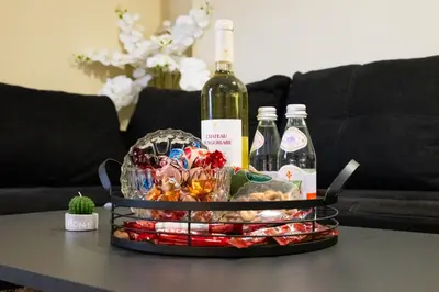a basket of food and bottles of wine on a table at Top City Centre Apartment 122 in Sofia