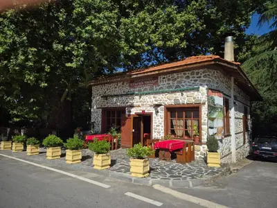 a small building with tables and chairs in front of it at Стария Чинар in Melnik