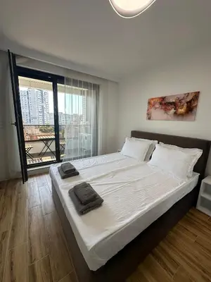 a bedroom with a large bed with white sheets and a window at D&G City Homes in Sofia