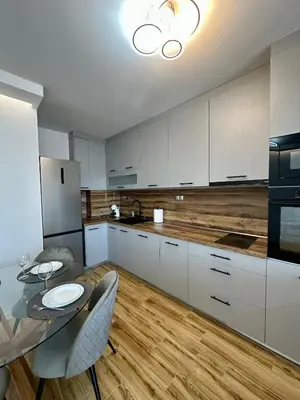 a kitchen with white cabinets and a table with chairs at D&G City Homes in Sofia