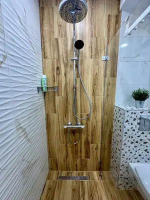 a shower in a bathroom with a wooden wall at D&G City Homes in Sofia