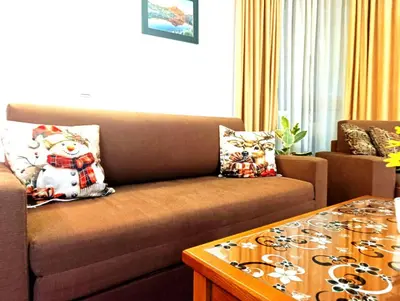 a living room with a couch and a coffee table at Pirin View Apartment in Bansko