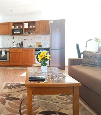 a living room with a coffee table and a kitchen at Pirin View Apartment in Bansko