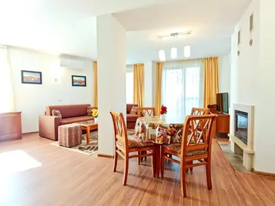 a living room with a table and chairs and a couch at Pirin View Apartment in Bansko