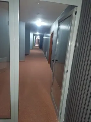a hallway of an office with glass doors and a hallwayngthngthngthngthngth at Pirin View Apartment in Bansko