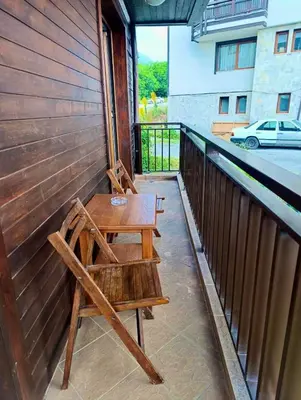 a wooden table and bench on a balcony at Pirin View Apartment in Bansko