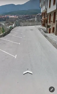 an empty parking lot with a white object in the street at Pirin View Apartment in Bansko