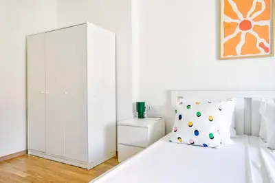 a white bedroom with a bed and a cabinet at Scandinavian Charm - Central 1BD with Desk by Flat Manager in Sofia