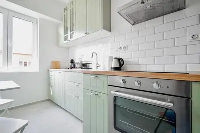 a kitchen with green cabinets and a stove at Scandinavian Charm - Central 1BD with Desk by Flat Manager in Sofia