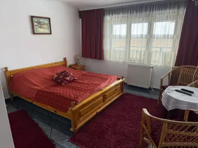 a bedroom with a bed with a red comforter at Къща за гости Гаджо Gadjo in Bansko
