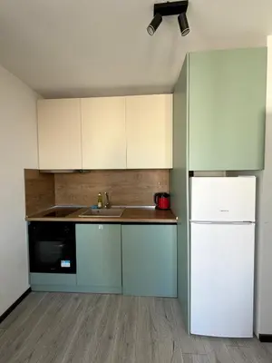 a kitchen with white cabinets and a sink and a refrigerator at Stay Point One Bedroom Apartment Including Underground Parking Place in Sofia