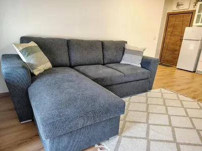 a blue couch sitting in a living room at White Peak 2rooms ap in Bansko