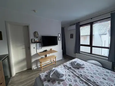 a bedroom with a bed and a desk and a television at Luxury Studio2 in Hotel Friends in Bansko
