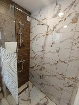 a bathroom with a shower with a stone wall at Green Apart Residence Including Parking Place in Sofia