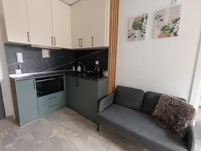 a living room with a couch and a kitchen at Green Apart Residence Including Parking Place in Sofia
