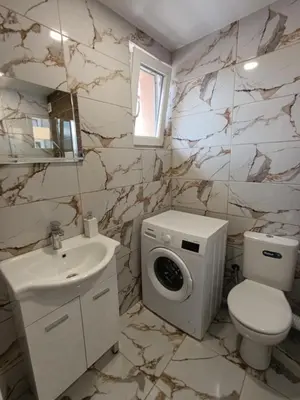 a bathroom with a toilet sink and a washing machine at Green Apart Residence Including Parking Place in Sofia