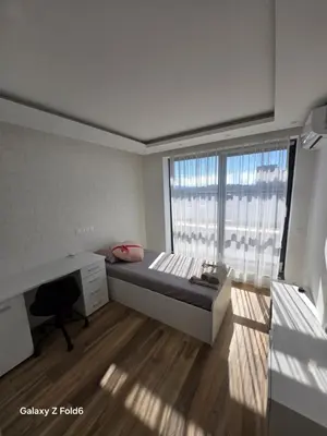 a bedroom with a bed and a desk and a window at Dilyanka 3 in Pernik