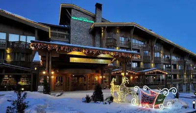 a hotel with christmas decorations in front of it at Nature Escape to Pirin Golf in Razlog