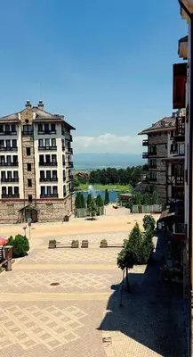 a large courtyard with two buildings and a park at Nature Escape to Pirin Golf in Razlog