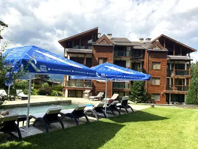 a group of chairs and umbrellas next to a pool at Nature Escape to Pirin Golf in Razlog