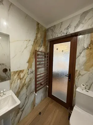 a bathroom with a sink and a toilet and a window at Just a Dream - guest apartments in Troyan