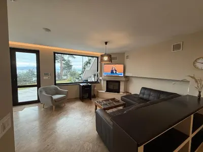 a living room with a couch and a tv at Premium Studio Apartment in Private Villa Nisim in Batak
