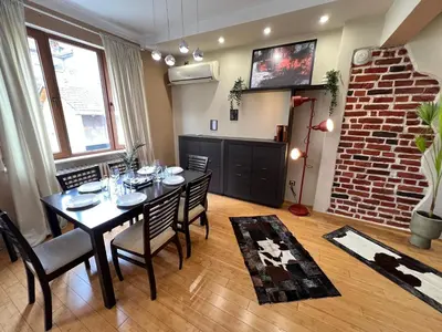a dining room with a table and chairs and a brick wall at Hamburg 100 Sq M 2BDR Family Apt near NDK and Vitosha BLVD in Sofia