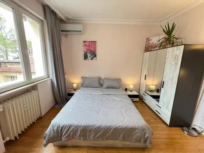 a bedroom with a large bed and two windows at Hamburg 100 Sq M 2BDR Family Apt near NDK and Vitosha BLVD in Sofia