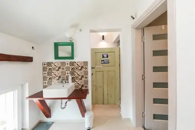 a bathroom with a sink and a door at Cozy family loft at Women's market in Sofia