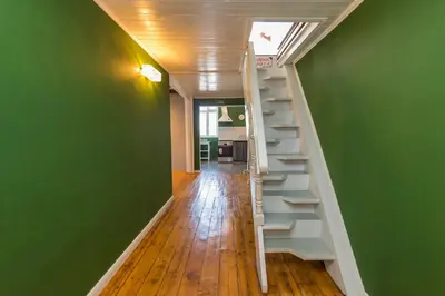 a staircase in a room with a green wall at Cozy family loft at Women's market in Sofia