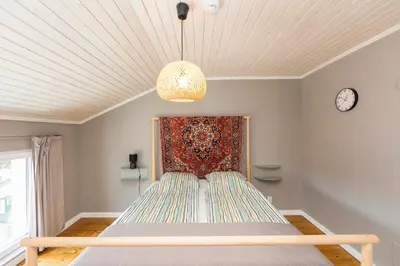 a bed in a room with a clock on the wall at Cozy family loft at Women's market in Sofia